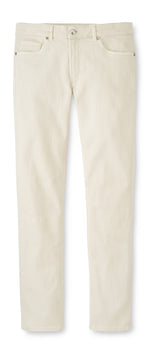 The Peter Millar Fairfield Garment Dyed Denim jeans feature a straight-leg, light beige cotton-stretch fabric, front and back pockets, button closure, and belt loops—laid flat on white; versatile for three-season casual wear.