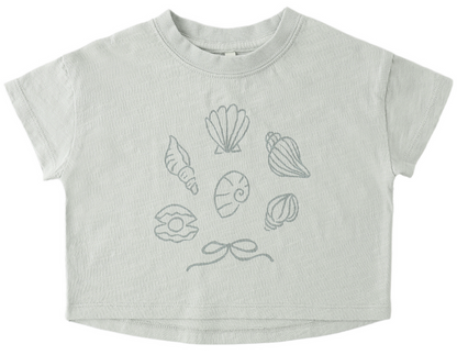 The Rylee & Cru Baby Girls' and Girls' Boxy Tee features a light gray boxy fit, short sleeves, six seashell line drawings, and a small bow on the front—perfect for little beach lovers.