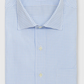 The Sid Mashburn Spread Collar Dress Shirt is a light blue and white checkered poplin shirt with a spread collar, white buttons, and a green label on the inside collar.