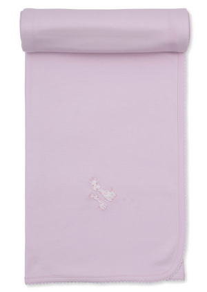The Kissy Kissy Giraffe Laughs Blanket is a light pink Pima cotton baby blanket featuring scalloped edges and an embroidered giraffe design near the center, shown partially rolled at the top.