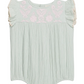 The Louise Misha Baby Girls’ Nusha Romper features light green cotton gauze with short ruffle sleeves, pink floral embroidery on the chest, and gathered fabric detailing.