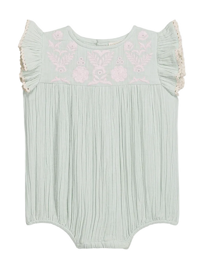 The Louise Misha Baby Girls’ Nusha Romper features light green cotton gauze with short ruffle sleeves, pink floral embroidery on the chest, and gathered fabric detailing.