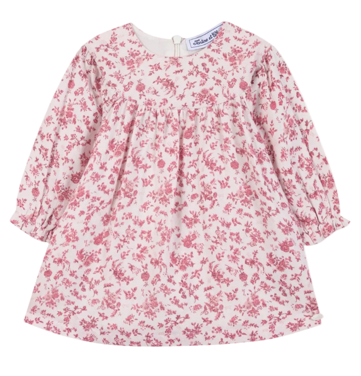 The Tartine et Chocolat Girls’ Floral Print Cotton Dress features a soft unbleached cotton fabric with a pink floral print on a white background, designed with long sleeves, a round neckline, and a gathered waist.