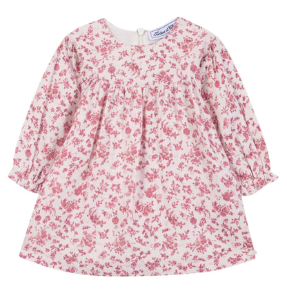 The Tartine et Chocolat Girls’ Floral Print Cotton Dress features a soft unbleached cotton fabric with a pink floral print on a white background, designed with long sleeves, a round neckline, and a gathered waist.