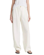 A person wears Vince's Hemp Utility Pant—breathable, loose-fitting white linen—with a sleeveless top and black sandals, creating a relaxed silhouette against a plain background.