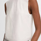 A person wears the vince Linen Crew Neck Shell Tank in white with light gray high-waisted pants, shown from shoulders to waist against a plain background. The breathable linen blend enhances comfort and offers a simple, refined look.
