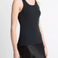 A person wearing the Vince Ribbed Scoop Neck Tank in black and a black satin skirt, shown from the shoulders to the knees against a plain background.