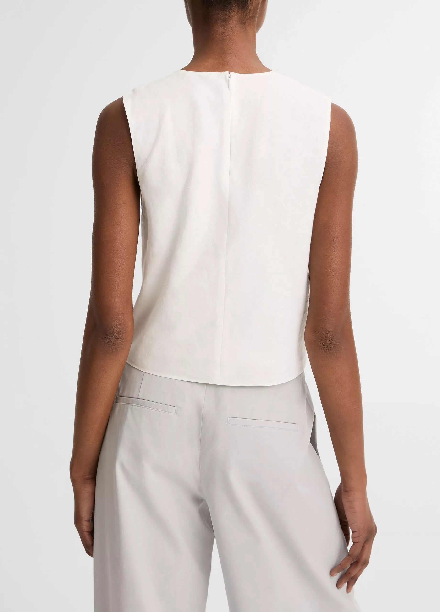 A person is shown from the back against a white background wearing the vince Linen Crew Neck Shell Tank with light gray pants, highlighting its breathable linen-blend fabric.
