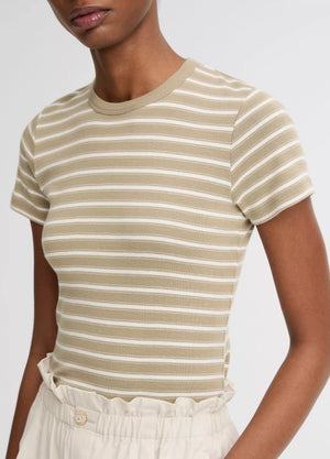 A model wears the vince Stripe Shrunken 90s Tee—a beige and white striped, shrunken-fit top—tucked into high-waisted, light-colored pants, shown from shoulders to waist.