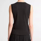 A person shown from the back against a plain light background wears the vince High V-Neck Shell Tank in black, paired with a black pleated skirt.