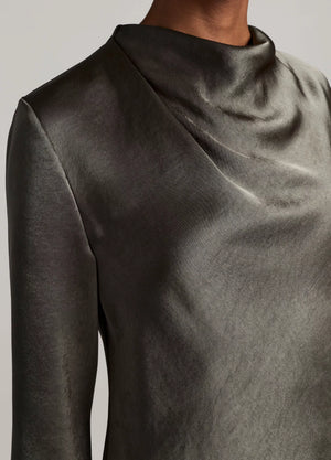 Close-up of a person wearing the Vince Long Sleeve Draped Cowl Blouse in dark gray, featuring a softly draped and pleated neckline.