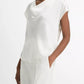 A woman wearing the Vince Cowl Neck Cap Sleeve Silk Blouse, styled in a loose fit and paired with matching white trousers, stands against a plain white background.