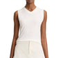 A person wears the vince High V-Neck Shell Tank, a sleeveless white top, tucked into high-waisted off-white pants; shown from shoulders to hips.