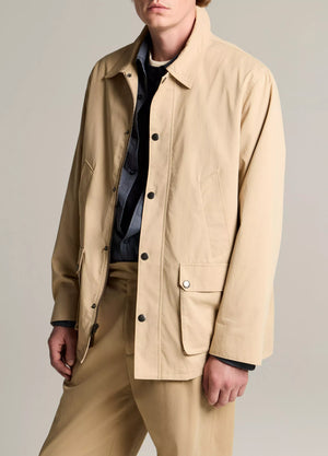 A person wearing the Vince Lightweight Barn Jacket in beige peached cotton with matching trousers over a dark shirt, standing against a neutral background.