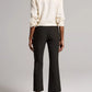 Back view of a person wearing black Niki Mid Rise Crop Flare pants and white heeled mules.