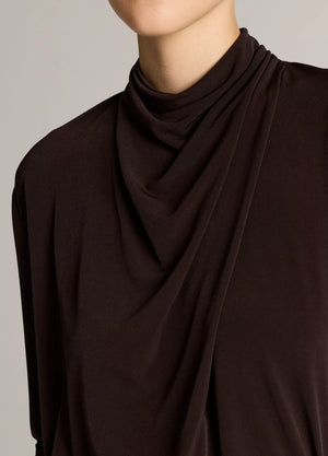 A person wears the vince Long Sleeve Draped Cowl Blouse in black matte jersey; only the lower half of their face and upper torso are shown against a neutral background, emphasizing the blouse’s elegant, versatile silhouette.
