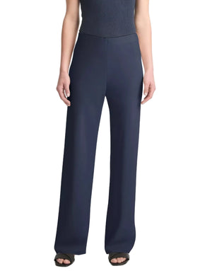 A person wearing the vince Colette High Waist Pant in navy—high-waisted, wide-leg crepe trousers with an elastic waistband—paired with black open-toe sandals, shown from the shoulders down against a white background.
