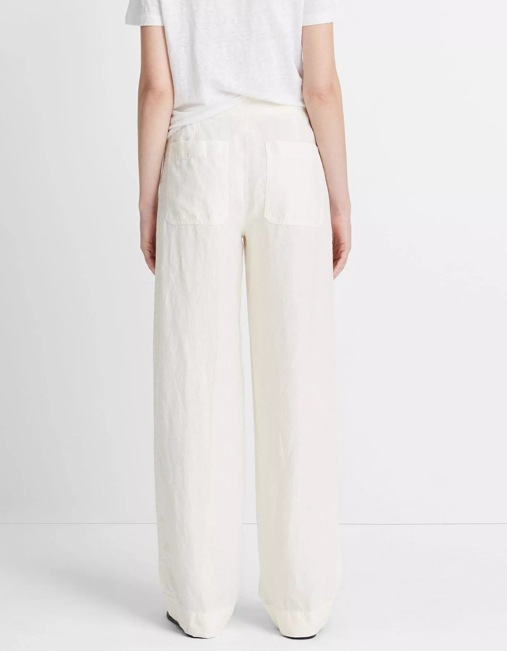 Model wears a white t-shirt and vince Hemp Utility Pant, featuring a relaxed silhouette and breathable fabric, shown from the back against a plain white background.