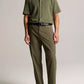 A man wearing the vince Pointelle Short Sleeve Button Down in olive, paired with matching olive trousers, a black belt, and black shoes, stands against a plain background.