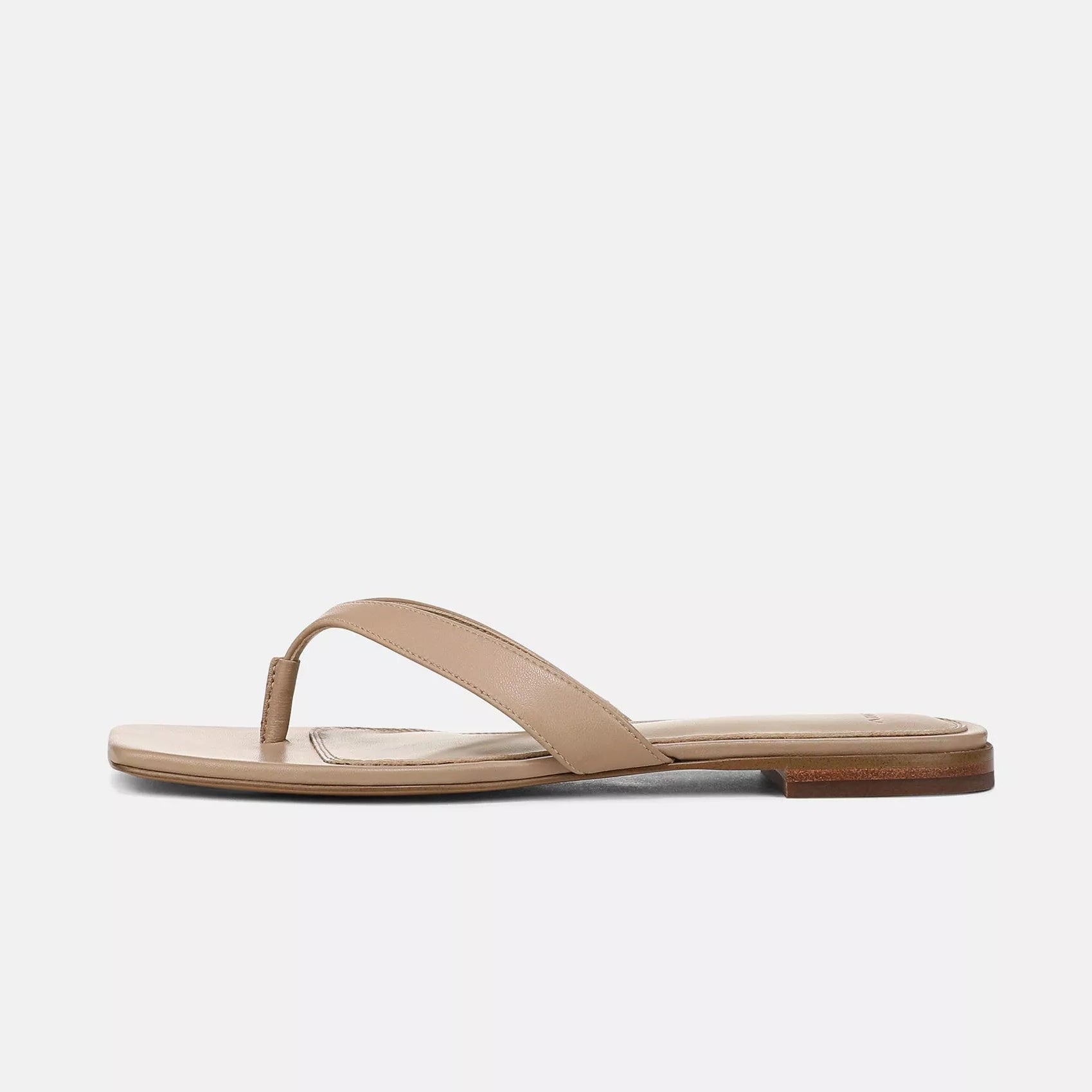 The Vince San Juan Leather Thong Sandal is shown from the side against a plain white background, featuring tan leather straps, a low wooden heel, and a padded footbed.