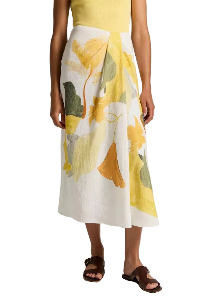 A person wearing a yellow sleeveless top, the vince Painted Abstract Draped Skirt, and brown sandals.