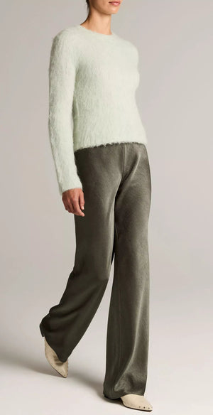 A person wearing a fuzzy light sweater, the Vince Colette High Waisted Fluid Satin Bias Pant, and cream pointed shoes stands against a plain background.