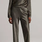 A person wearing the Vince Long Sleeve Draped Cowl Blouse paired with matching wide-leg pants in olive green, standing against a plain background.
