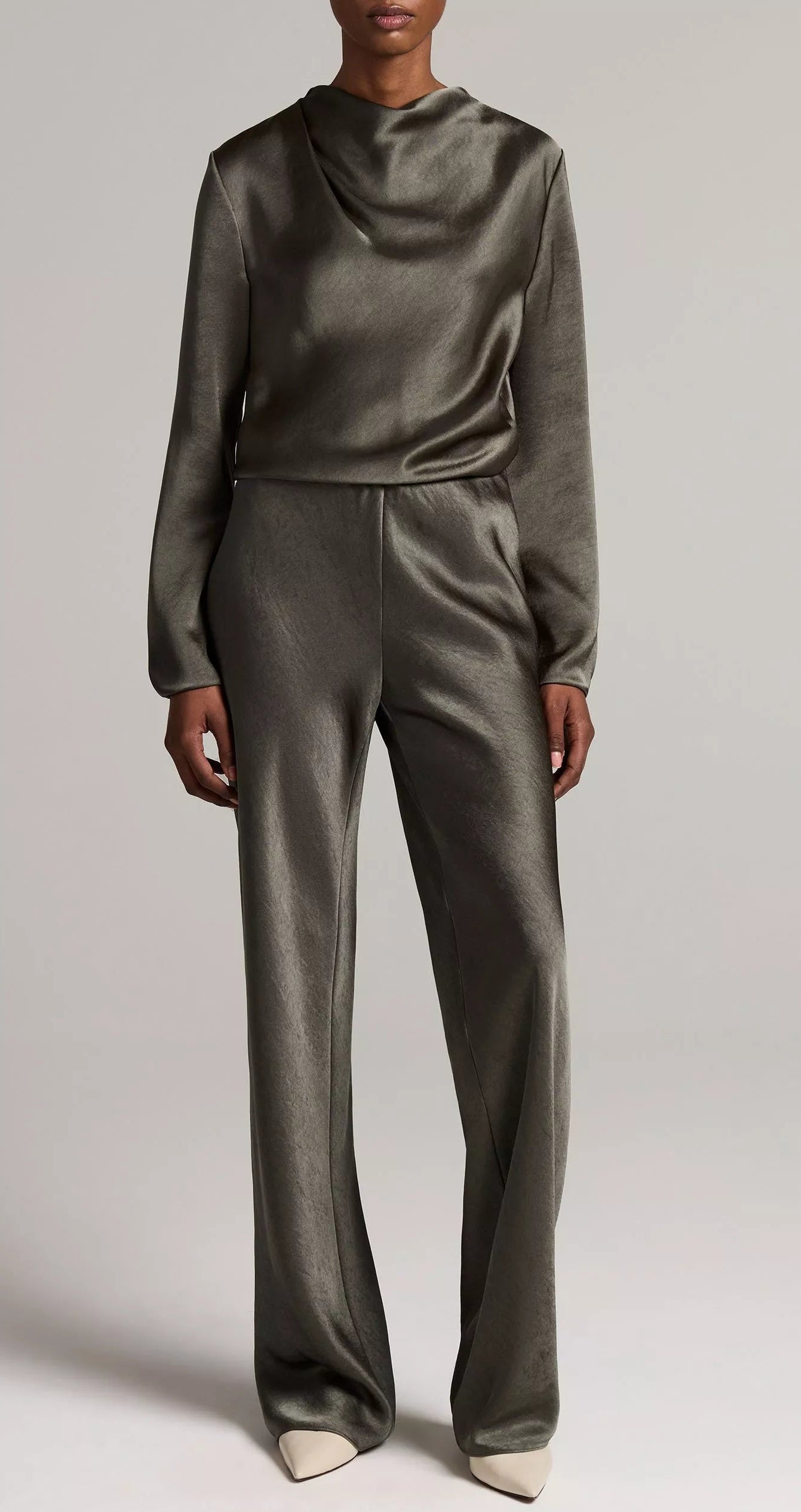A person wearing the Vince Long Sleeve Draped Cowl Blouse paired with matching wide-leg pants in olive green, standing against a plain background.