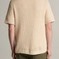 A person is shown from the back against a plain background, wearing the vince Crochet SS Button Down in beige with olive green pants.