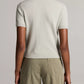 A person stands facing away, wearing the Vince Relaxed Short Sleeve Crew Sweater—crafted from lightweight wool cashmere—and olive green pants. The background is plain and neutral.