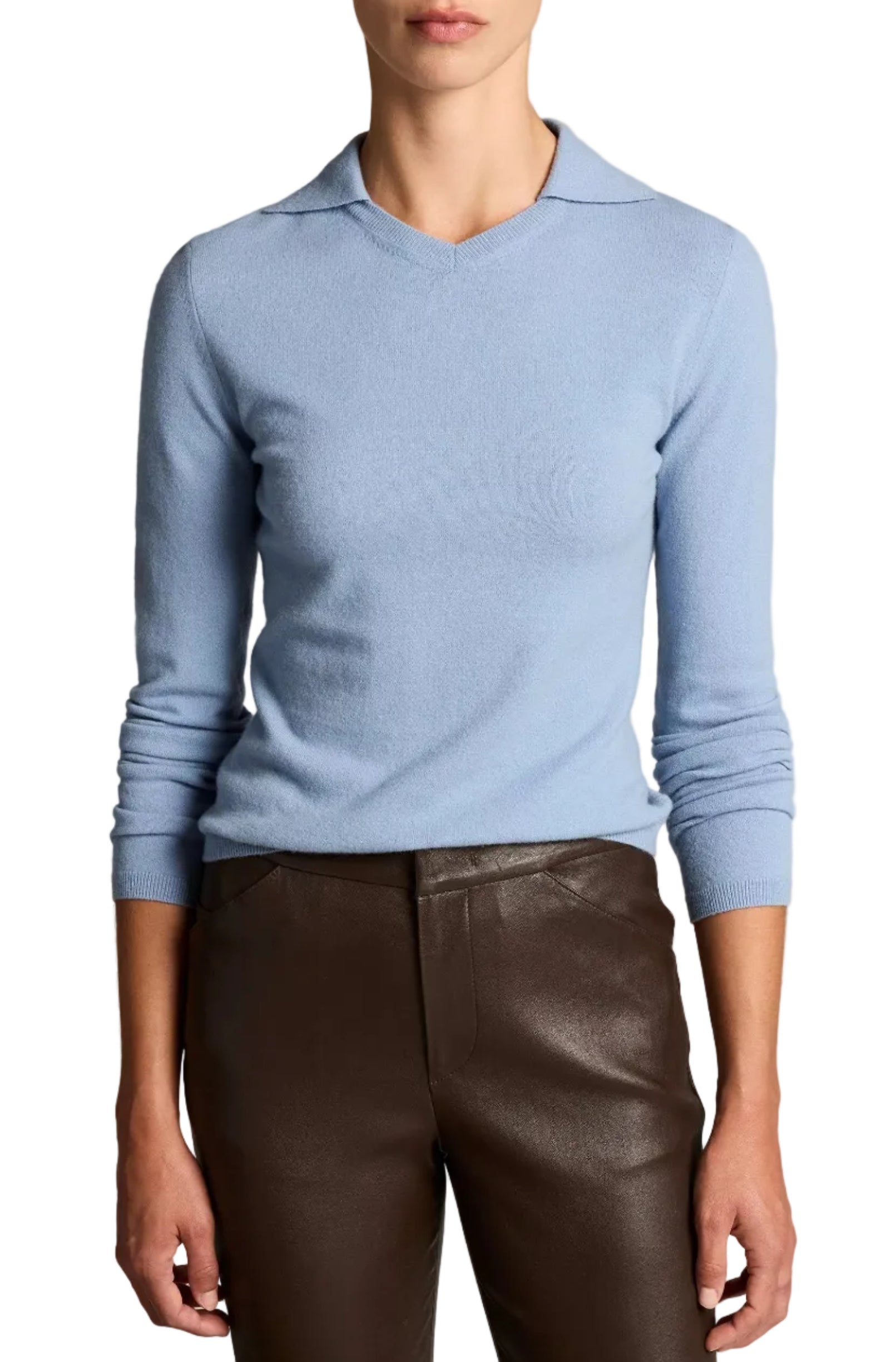 A person wearing the Vince Long Sleeve High V-Neck Polo Sweater in light blue, paired with dark brown pants, stands against a plain background.