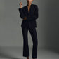 A person stands against a plain background wearing the vince Niki Mid Rise Crop Flare Pant in black Italian cotton-blend fabric, styled without a shirt and paired with sleek black flat shoes.