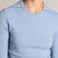 A person wearing the Vince Long Sleeve High V-Neck Polo Sweater in light blue, shown from shoulders to mid-torso against a neutral background.