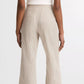 A person faces away, wearing a white sleeveless top, vince Low Rise Ticking Striped Crop Flare Trouser, and sandals.