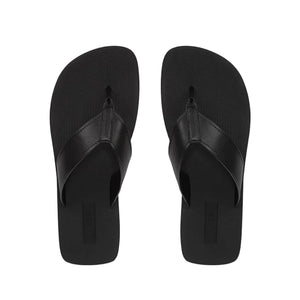 A pair of Fiji Suede Thong Sandals by vince in plain black, minimalist design, shown from above against a white background.