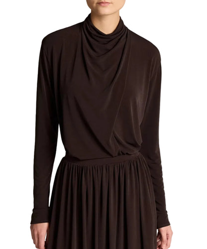 A person is shown from the shoulders to just above the knees, wearing the Vince Long Sleeve Draped Cowl Blouse and a matching dark brown skirt in matte jersey, photographed against a white background.