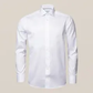 The Eton White Signature Twill Shirt, Contemporary Fit features a classic collar and long sleeves in wrinkle-free fabric, showcased against a beige background—a timeless display of elegance.
