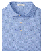 A folded light blue Peter Millar Barrier Performance Jersey Polo features a small geometric pattern, three beige buttons, and four-way stretch for unmatched comfort.