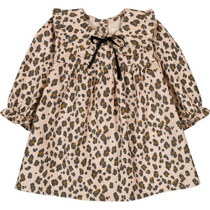 The Louis Louise Baby Girls' Benjamina Corduroy Leopard Dress features long sleeves, an all-over leopard print on beige, a ruffled Peter Pan collar, and a small black bow at the neckline.