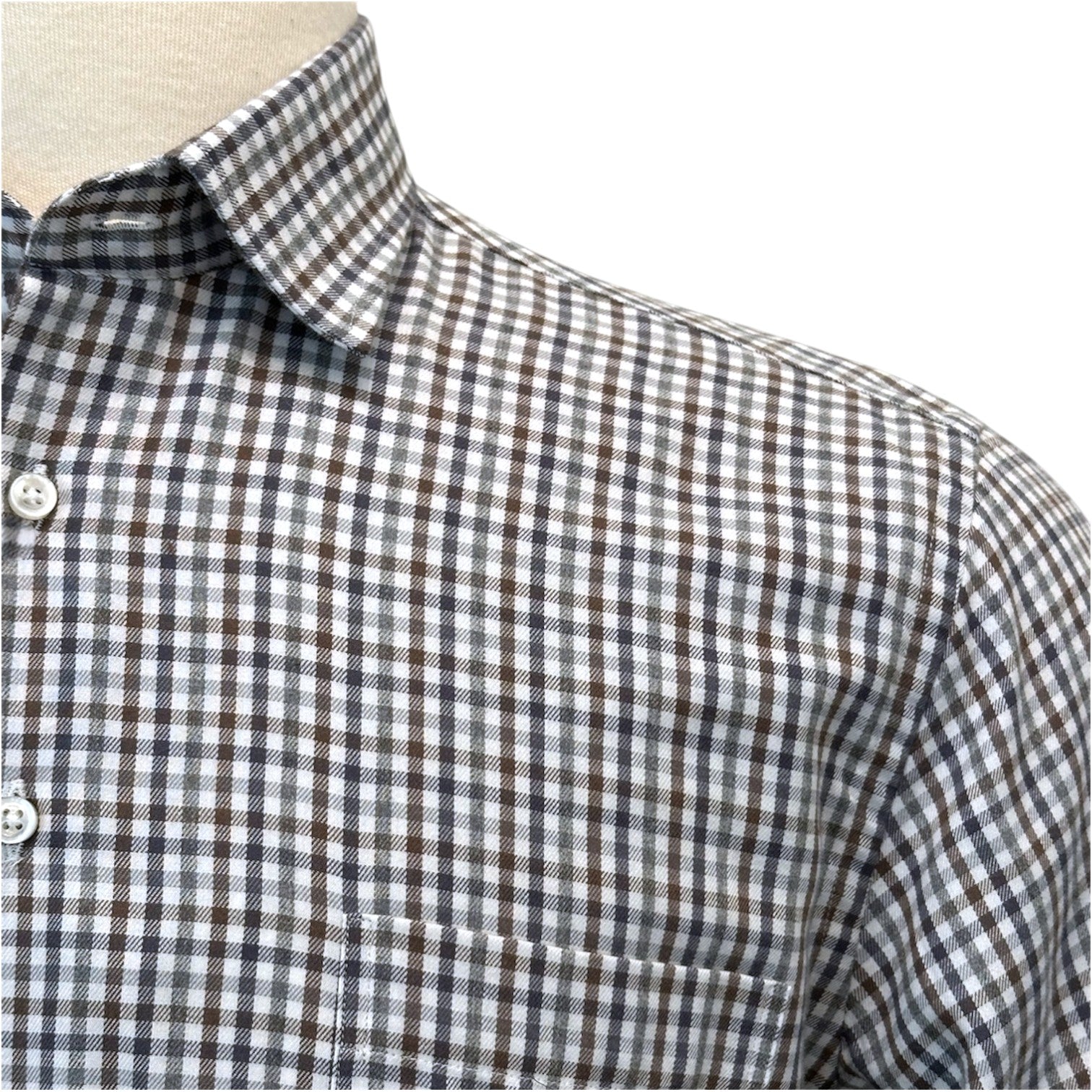 Close-up of the Dunsdale Woven Shirt by Alan Paine, featuring a black, white, and gray checked pattern, chest pocket, white buttons, and a refined fit for timeless appeal.