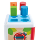 The Hape Shape Sorting Box is a toddler educational toy with four colorful shapes—triangle, rectangle, circle, and cross—that fit into matching slots on a white and blue box.
