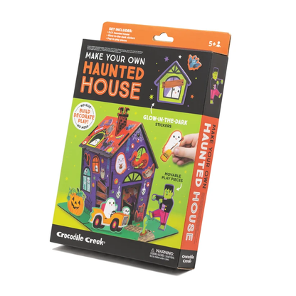 The Crocodile Creek Make Your Own Haunted House craft kit, shown in its product box with glow-in-the-dark stickers and pop-in play figurines.