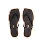 A pair of Tkees Dylan Sandals for women in black with square toes and tan soles, handcrafted from Brazilian leather, shown from above on a white background.