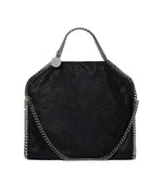 The Stella McCartney Falabella Fold Over Tote is a black, rectangular vegan bag made from recycled plastic bottles, featuring a metallic chain handle and trim with a slight sheen, shown against a white background.
