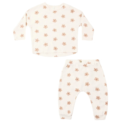 Introducing the Rylee & Cru Baby Girls’ Long Sleeve Tee + Pant Set: this cream-colored two-piece outfit is made from soft cotton jersey and features a coordinating long-sleeve tee and slouch pants, both decorated with a subtle light brown floral pattern and presented against a white background.