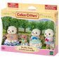 The Calico Critters Sea Otter Family toy set includes four plush otter figures dressed in charming fabric outfits with a subtle shell motif, attractively displayed outdoors on the packaging.