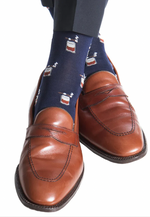 Dapper Classics Bourbon with Cigars Mid Calf Socks in navy and brown offer a luxurious feel, crafted from mercerized cotton. These socks feature a playful cigar pattern for added style, providing comfort with their mid-calf fit, and are proudly made in the USA.