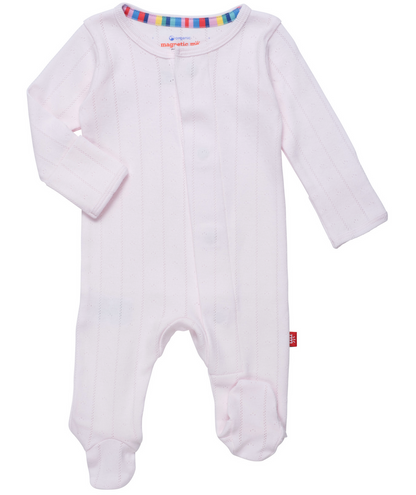 The Baby Love Lines Pointelle Footie by Magnetic Me is a light pink onesie made from organic cotton, featuring long sleeves and a front magnetic closure. It has a striped collar lining in assorted colors, making it an essential for any baby wardrobe.
