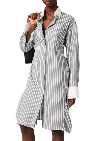 A person wearing the Stella McCartney Long Sleeve Pinstripe Shirt Dress, featuring white cuffs and collar, and holding a black bag.