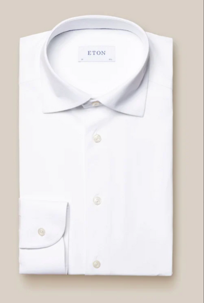 A slim-fit Four-Way Stretch Shirt by Eton, long-sleeve, white with a pointed collar and button cuffs, crafted from breathable tech fabric. Displayed on a neutral background with the "Eton" label inside the collar.